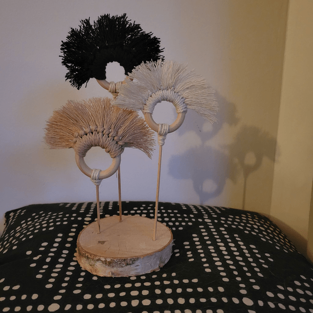 Décoration en corde de macramé et laine sur rondin de bois.